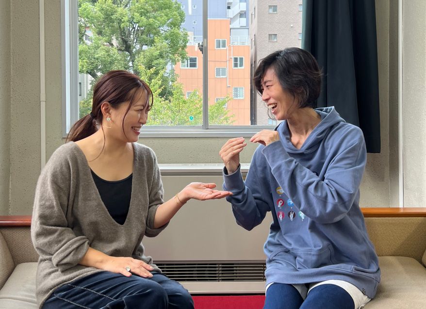 ソファに座って向き合い、笑顔の二人